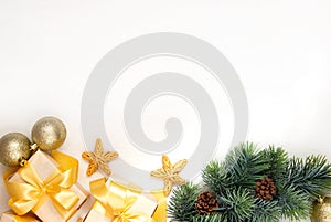 New Year`s gifts with a golden bow, a fir branch on a light background. Flat lay, top view, copy space for text. Christmas festiv