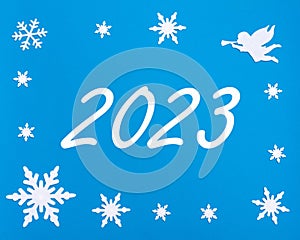 New Year's greeting card. The calendar date 2023 on a blue background with Christmas snowflakes, a white angel