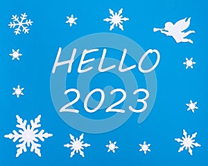 New Year's greeting card. The text HELLO 2023 on a blue background with Christmas snowflakes, a white angel.