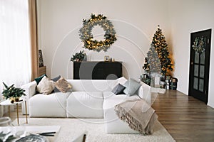 New Year`s interior. Decorated Christmas tree with gifts. Wreath of spruce with garland. Christmas decorations