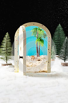 New Year`s magic. Christmas tree, miniature door overlooking the beach and palm trees.