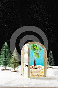 New Year`s magic. Christmas tree, miniature door overlooking the beach and palm trees.