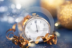 New Year\'s at midnight - Old clock with Christmas decoration, champagne and holiday lights