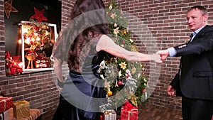 New Year`s party near the Christmas tree, family is beautiful dances in the house, romantic moment for a husband and