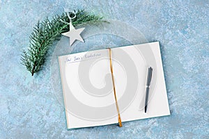 New Year's resolutions, flat lay top shot with a place for text, on a blue background with a Christmas decoration and a