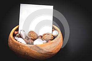 New Year`s resolutions, Wooden bowl with nuts, walnuts and hazelnuts, copy space on black background