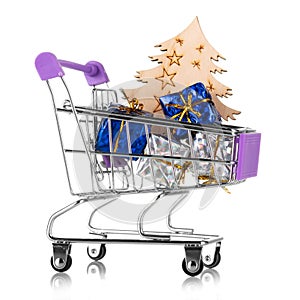 New Year`s sales. Shopping cart with gifts and wooden christmas tree isolated on white
