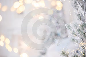 New Year`s silver shiny ball hanging on a fir branch. Lights and garlands on a gray snow background. Christmas and happy new year