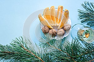 New Year`s still life - a glass of champagne, Christmas decorations and spruce branches on blue background