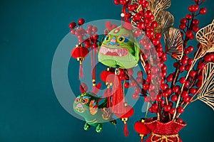 A New Year's toy in the shape of a green dragon hangs on a branch tree. Festive background. Chinese horoscope