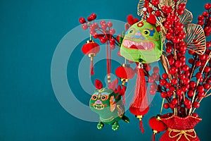 A New Year's toy in the shape of a green dragon hangs on a branch tree. Festive background. Chinese horoscope