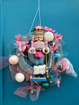 New Year`s wreath with a figure of a nutcrack hanging on a wooden door
