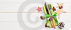 New year set of Banner fork and knife on napkin. Top view of christmas decorations and reindeer on wooden background. Holiday