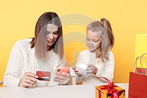 New Year shopping online concept. Mother showing daughter something on the phone.