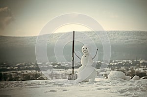 New year snowman from snow with shovel.