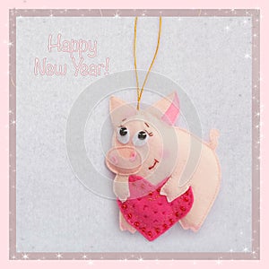 New year. Soft toy made of felt. The cute pig. Piglet is holding a heart. Christmas tree decoration. Symbol of year. 2019.