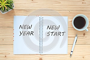 New Year New Start with notebook, black coffee cup, pen and glasses on table, Top view and copy space. Resolution, Start, Goals, S