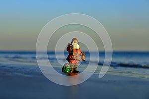 New Year travel. Winter holidays on hot beach. Toy summer Santa. Christmas banner, poster or greeting cards.