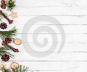 New year white wooden background with fir tree, cones and natural christmas decorations on left side