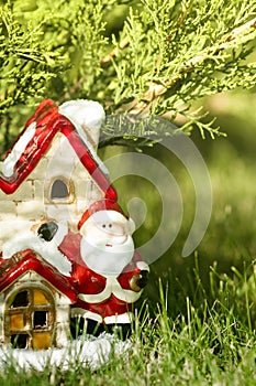 New Year Winter Composition. Santa`s house, toy Santa under the tree
