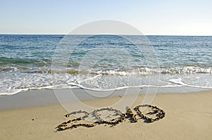 New year written on the deserted beach.