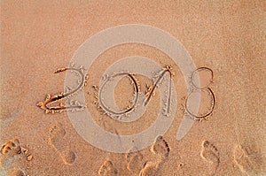 New Year written on sandy beach 2018 is coming like date holiday concept