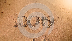 2019 New Year written on wet sand on the ocean beach. Concept of winter holidays, Christmas and tourism