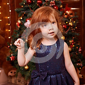 New Year xmas child. Christmas eve holiday. Beautiful little girl. Christmas interior. Blue dress