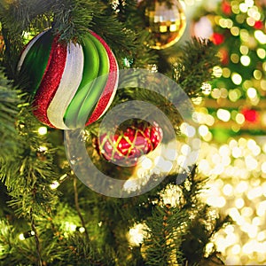New year and xmas tree decorations with striped ball and red bauble, close-up