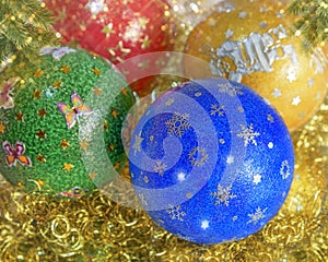 New Years, Christmas still life. Handmade decorated green, red, blau, yellow balls on the gold tinsel. Close up