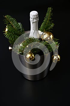 New Years decor, a bottle of champagne, fir branches and golden balls