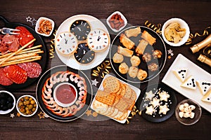 New Years Eve appetizer table scene. Above view on a dark wood background.