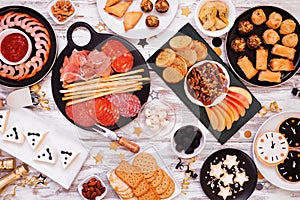 New Years Eve appetizer table scene. Top view on a white wood background.