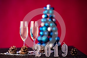 New Years 2019 Eve celebration background with pair of flutes, on christmas decoration on background