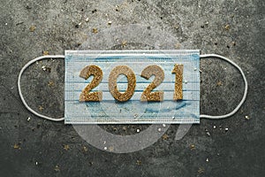 New Years Eve celebration concept background.Medical mask with the numbers 2021.Covid-19 New Year concept