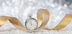 New Years eve celebration party. Minutes to midnight on an old watch, bokeh festive background