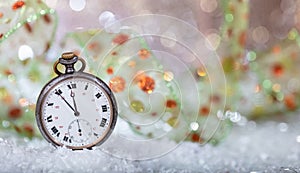New Years eve countdown. Minutes to midnight on an old watch, bokeh background
