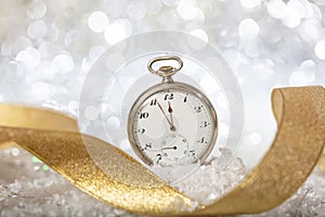 New Years eve countdown. Minutes to midnight on an old watch, bokeh festive