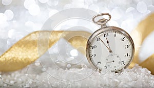 New Years eve countdown. Minutes to midnight on an old watch, bokeh festive background