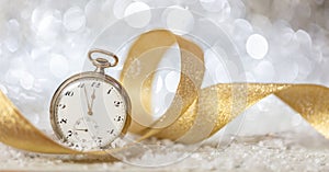 New Years eve countdown. Minutes to midnight on an old watch, bokeh festive background