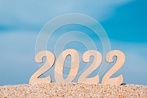 New Years numbers 2022 on a sandy beach against the sky. Creative Christmas card. Copy space. Selective focus