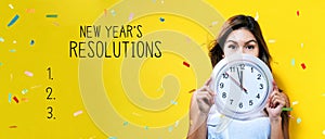 New years resolution with young woman holding a clock photo