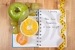 New years resolutions written in notebook and tape measure