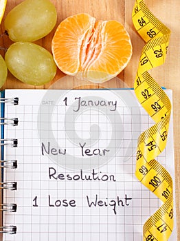 New years resolutions written in notebook and tape measure