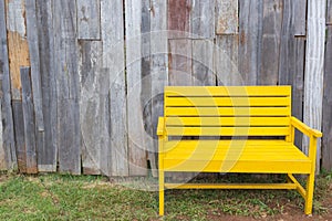 New yellow chair with old wood wall