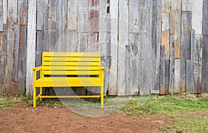 New yellow chair with old wood wall