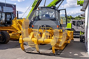 New yellow crawler bulldozer with ripper, rear view. Sale of new construction and municipal equipment at a dealership or