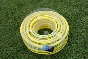 New yellow hose pipe in a garden