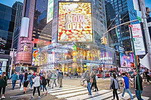 New York, Broadway streets at night. Illuminated high buildings, colorful neon lights, ads and people walking