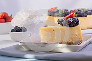 New York cheesecake on white plate decorated strawberry . Delicious moist and smooth baked blueberry cheesecake.